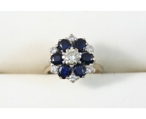 A SAPPHIRE AND DIAMOND CLUSTER RING set with a brilliant-cut diamond within a surround of six oval-shaped sapphires and six s