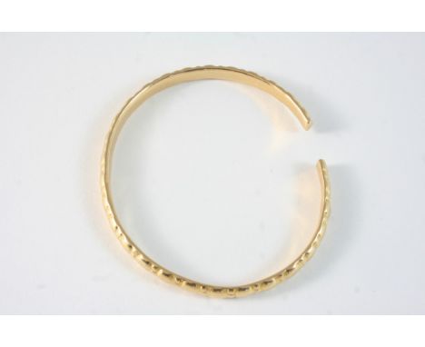 A GOLD BANGLE with embossed decoration, 30 grams.