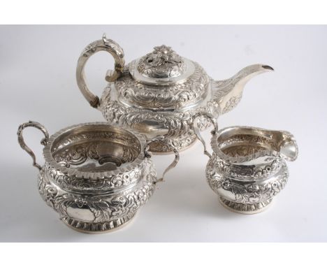 A WILLIAM IV IRISH THREE-PIECE TEA SET of circular form with embossed decoration, scroll handles & vacant cartouches, the tea