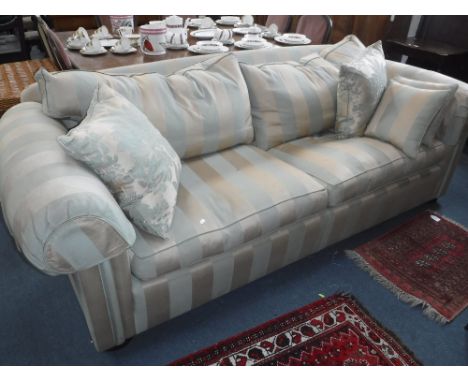 A LARGE SOFA with green and gold striped upholstery and a selection of scatter cushions, circa 95" wide