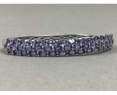 TANZANITE BANGLE,set with three rows of oval stones, in silver