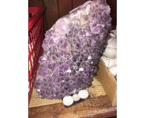 A geode rock on stand - possibly amethyst. 