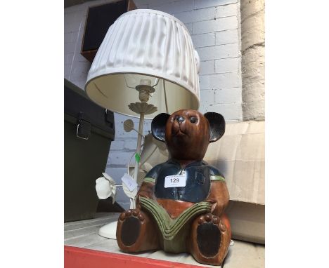 A wooden bear and a metal table lamp. 