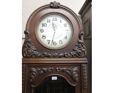 Early 20th Century Continental oak longcase clock with carved decoration, the circular silvered dial with Arabic numerals and