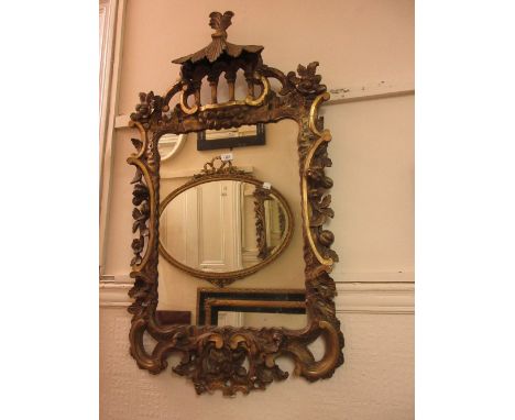 19th Century carved pine and gilded wall mirror in Chippendale style having pagoda top and carved C-scroll floral decoration,