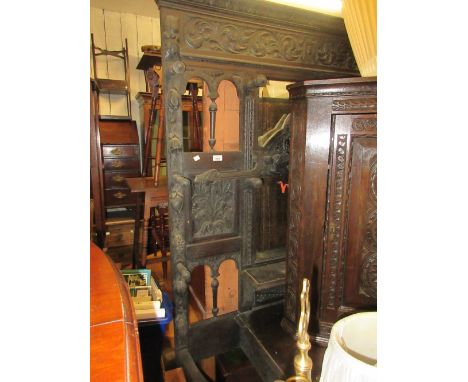 Large 19th Century carved oak hall stand with mask head pediment above a rectangular bevelled mirror with ten hat pegs and si