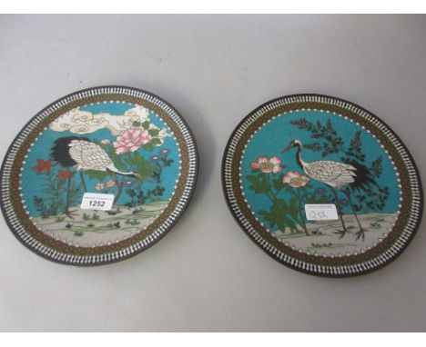 Pair of Japanese cloisonne plates decorated with cranes and flowering shrubs on a blue ground, 9.5ins diameter 