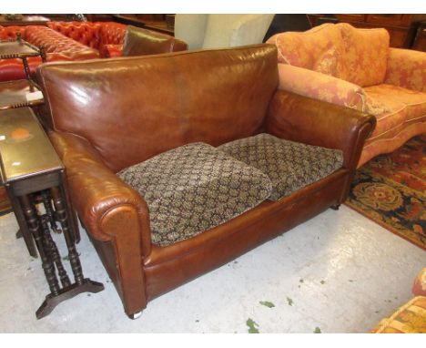 Early 20th Century brown leather upholstered two seater sofa with matching chair raised on turned front supports 