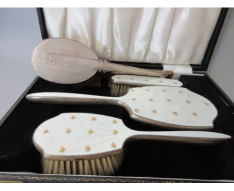 Cased silver gilt and enamel three piece dressing table set together with another silver mounted dressing table brush 