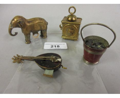 Four 19th Century tape measures in the forms of an elephant, coal bucket, mandolin and carriage clock 