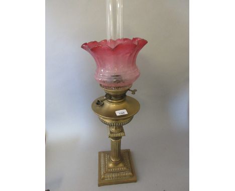 Brass Corinthian column oil lamp with etched cranberry glass shadeShade good, chips to base of chimney, oil well cap is missi