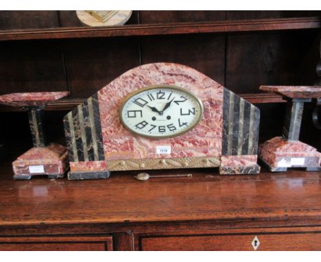 Large Art Deco red flecked marble and black and green onyx mounted three piece clock garniture, the oval enamel dial with Ara