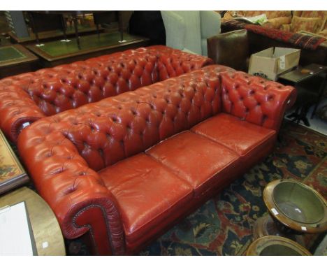Pair of 20th Century red buttoned leather upholstered three seat chesterfield sofas raised on low turned feetCigarette burn t
