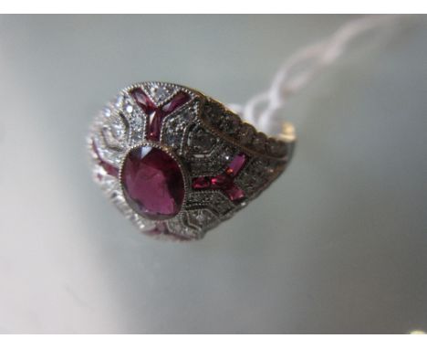 White metal Edwardian style diamond and ruby dress ring with a central oval shaped ruby 