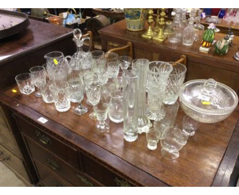 A collection of table glassware to include cut glass bowl and cover, various vases, decanter, and drinking glasses 