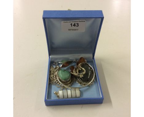 A white metal and amber coloured pendant, various other pendants, and a 925 Sterling silver bangle