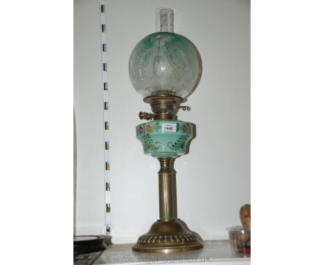 A Victorian Brass column Oil Lamp with green glass reservoir and green etched globe shade and chimney.