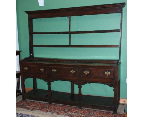 A Georgian Oak Farmhouse Dresser with rack, having moulded cornice to the two shelf rack with central reeded edge supports.  