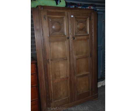 A French style Oak double doored Wardrobe, having moulded top over the pair of four panel doors, the top panel of each having