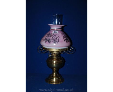 A Brass Oil Lamp with pink bird embossed shade