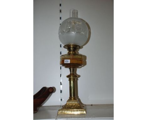 A Brass based Oil Lamp with double burner, glass reservoir and etched globe shade.