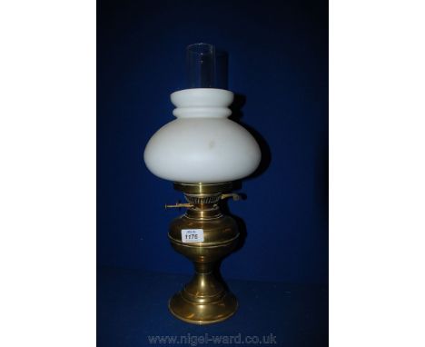 A Brass Oil Lamp with white frosted globe and clear chimney