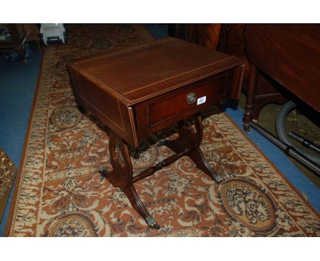 A reproduction mahogany Regency style Sofa Table, having cross banded top with two small drop leaves, single frieze drawer wi