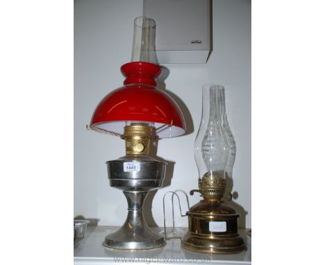 A Brass Oil Lamp with chimney and base, 17 1/4'' tall and a chrome and Brass Oil Lamp with red glass shade, 24'' tall