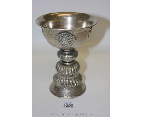 A fine and large Tibetan white metal butter lamp, probably c. 1900, with typical cast decoration, applied panels and engraved