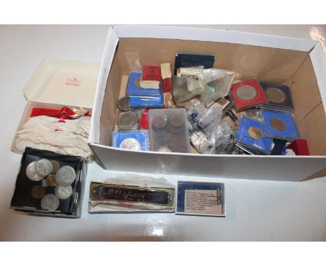 A box containing various coinage to include commemorative crowns, silver plated spoons, a Harmonica etc.
