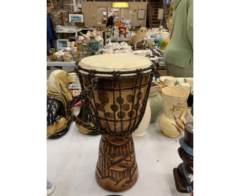 A WOODEN HAND CARVED BONGO DRUM 