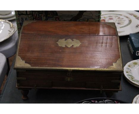 A VINTAGE STYLE MAHOGANY STATIONERY/JEWELLERY BOX ON FEET WITH BRASS CORNERS AND CARTOUCHE 