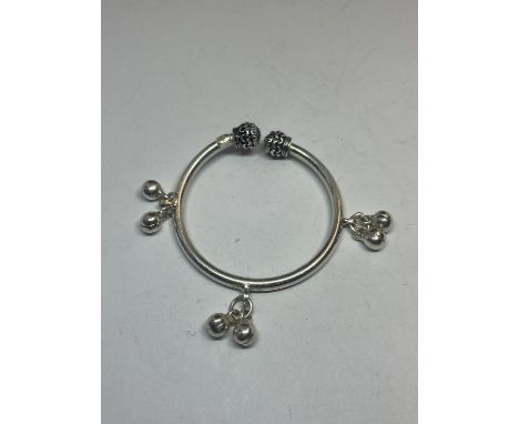 A BABY'S SILVER BANGLE WITH CHARMS 