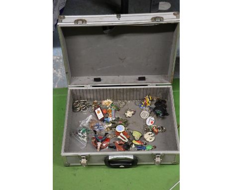 A METAL STORAGE CASE CONTAINING A SELECTION OF VINTAGE KEYRINGS AND FIGURES 