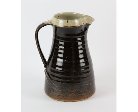 LEACH POTTERY, a tenmoku glazed pottery jug, with impressed marks, 23cm highNote: This pottery jug was given to the current v