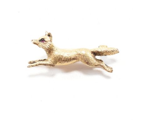 An antique ruby and yellow metal fox hunting interest brooch pin. The brooch in the form of a running fox with ruby cabochon 