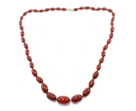 A vintage cherry bakelite beaded necklace. The early plastic retro necklace having graduating oval beads spaced on knotted th