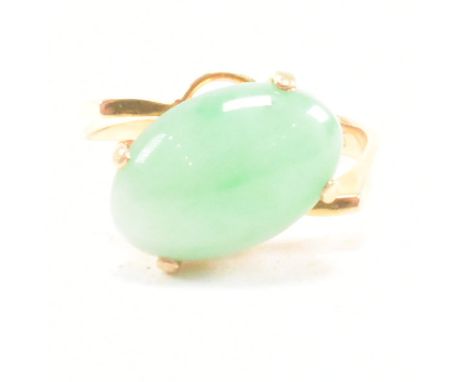A vintage 14ct gold and jade crossover ring. The ring set with a jade cabochon to a crossover mount. Marked 585. Test indicat