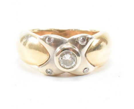 A 14ct gold and diamond ring. The ring set with a central bezel set diamonds to a kiss motif. Stamped 14k. Total weight 8g. S