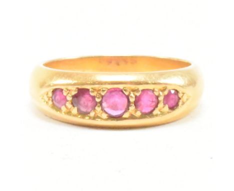 A gold and ruby five stone ring. The ring set with five graduating round cut rubies in a boat setting to tapering shank. Unma