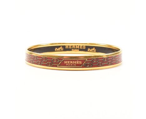 A vintage Hermes enamel bangle bracelet. The bangle of circular form having enamelled panel to the centre of the gold plated 