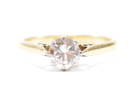 A hallmarked 18ct gold and diamond solitaire ring. The ring set with a round brilliant cut diamond to chenier shoulders and t