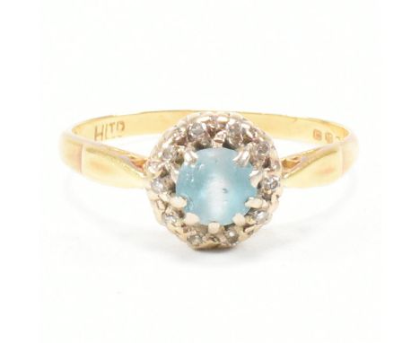 A vintage 18ct yellow gold, zircon and diamond halo ring. The ring having a round cut blue zircon surrounded in a halo of rou