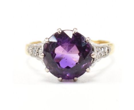 An early 20th century amethyst and diamond ring. The antique ring set with a round prong set mixed cut amethyst to cathedral 
