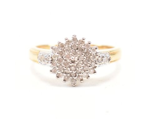 A hallmarked 18ct yellow gold and diamond cluster ring. The ring having a rounded head set with a cluster of round cut diamon