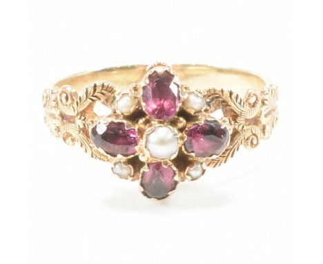 An antique Victorian pearl and garnet mourning cluster ring. The ring of yellow metal having a central round white pearl surr