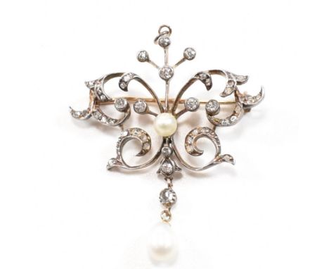 An Edwardian diamond and pearl brooch pin / necklace pendant. The brooch of scrolling open form set throughout with round cut