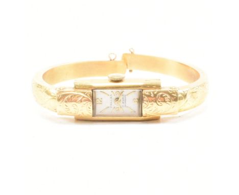 An 18ct gold Swiss Pallas hinged bangle watch. The watch having a rectangular white dial with batons and Arabic numerals. The