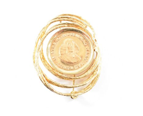 A vintage 18ct yellow gold mounted one Rand coin brooch pin. The brooch of brutalist style in textured metal spiral casing a 