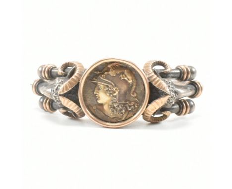 A vintage white and yellow metal Roman style bangle bracelet. The hinged bangle having a central coin style depiction of the 